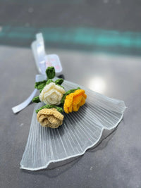 Handcrafted crochet flower bouquet with yellow, cream, and beige roses on sheer fabric