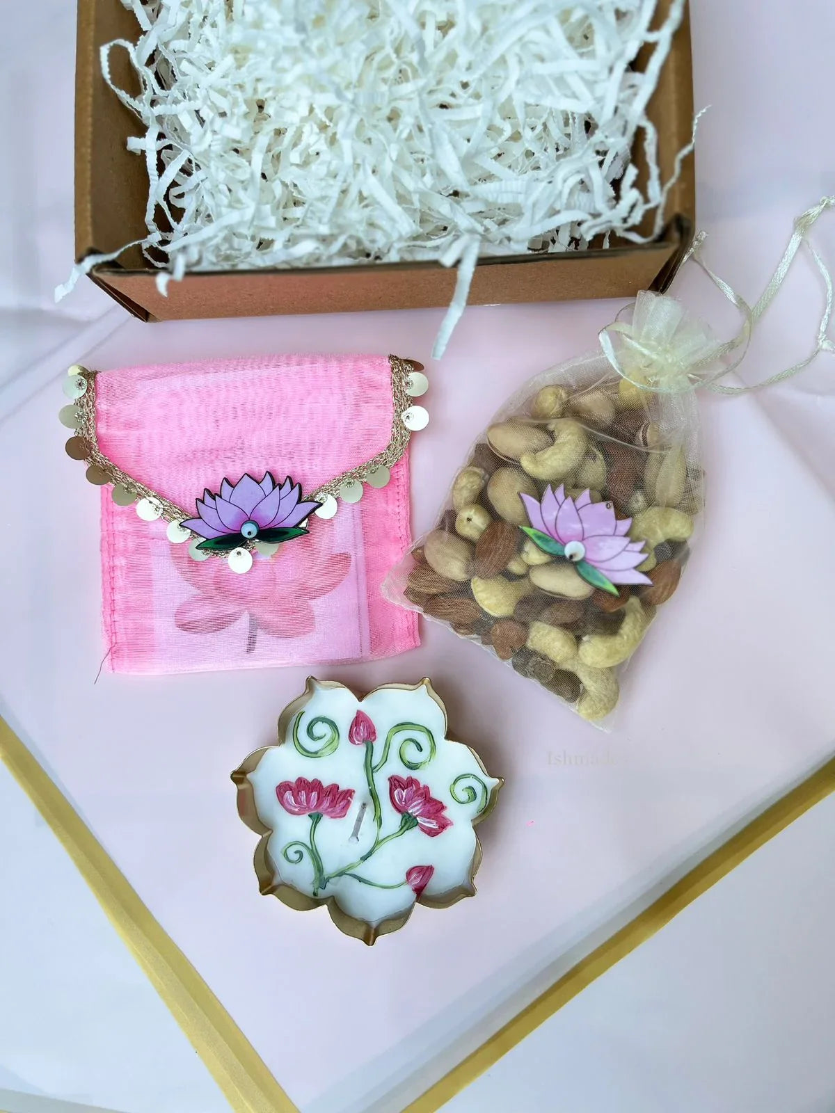 Gift box with pink lotus pouch, assorted dry fruits in organza bag, and decorative lotus candle